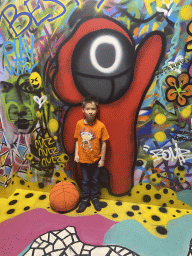 Max with a squid game painting at the graffiti room at the SuperNova Experience museum
