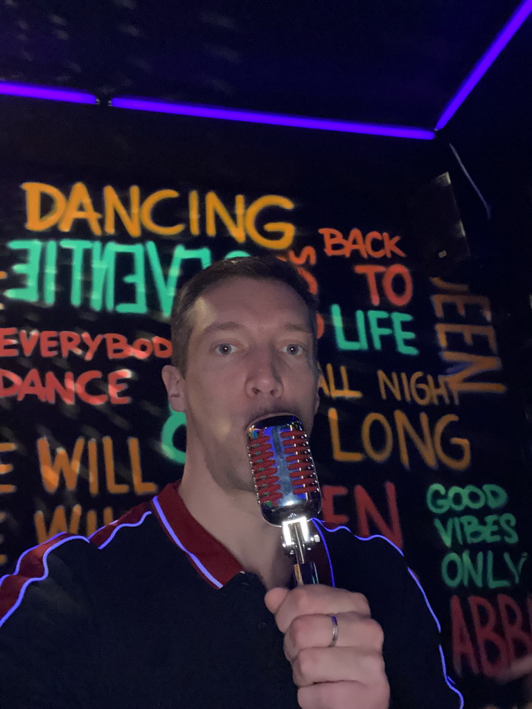 Tim with a microphone at the music studio room at the SuperNova Experience museum