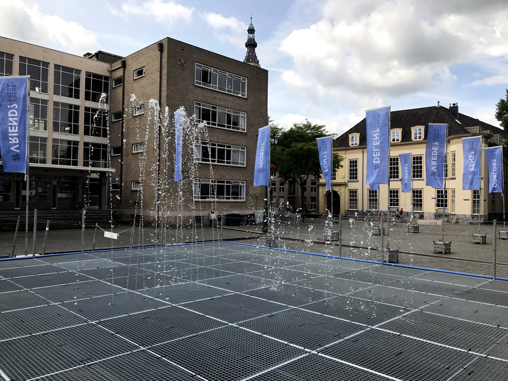 The Peace Fountain at the Kasteelplein square, with a view on the tower of the Grote Kerk church