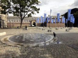 Max at a fountain at the Kasteelplein square, with a view on the Stadhouderspoort gate at the south side of the Breda Castle