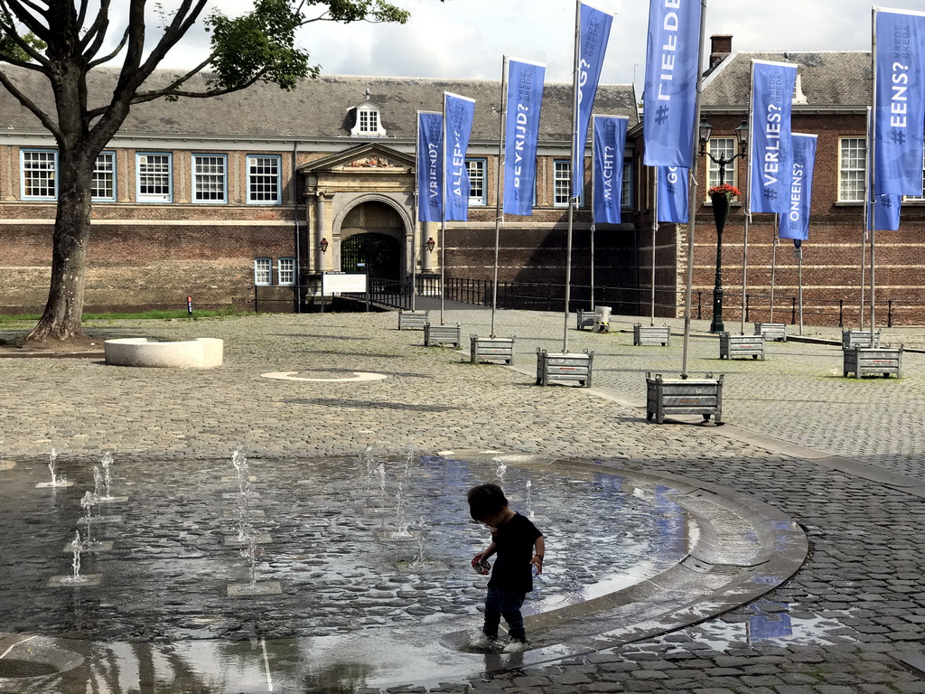 Max at a fountain at the Kasteelplein square, with a view on the Stadhouderspoort gate at the south side of the Breda Castle