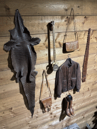 Items made from reptile skin on the wall of the Reptielenhuis De Aarde zoo, viewed from the staircase