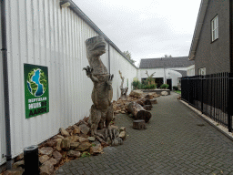 Entrance sign and statue of a Tyrannosaurus Rex at the entrance to the Reptielenhuis De Aarde zoo at the Aardenhoek street