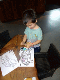 Max playing with a turtle statuette and drawings at the lower floor of the Reptielenhuis De Aarde zoo