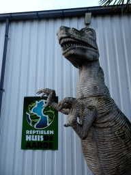 Entrance sign and statue of a Tyrannosaurus Rex at the entrance to the Reptielenhuis De Aarde zoo at the Aardenhoek street