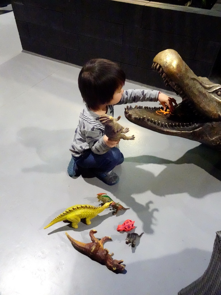 Max playing with dinosaur toys and a Crocodile statue at the lower floor of the Reptielenhuis De Aarde zoo