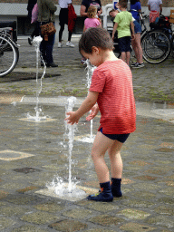 Max playing with the fountain at the Kasteelplein square, during the Nassaudag