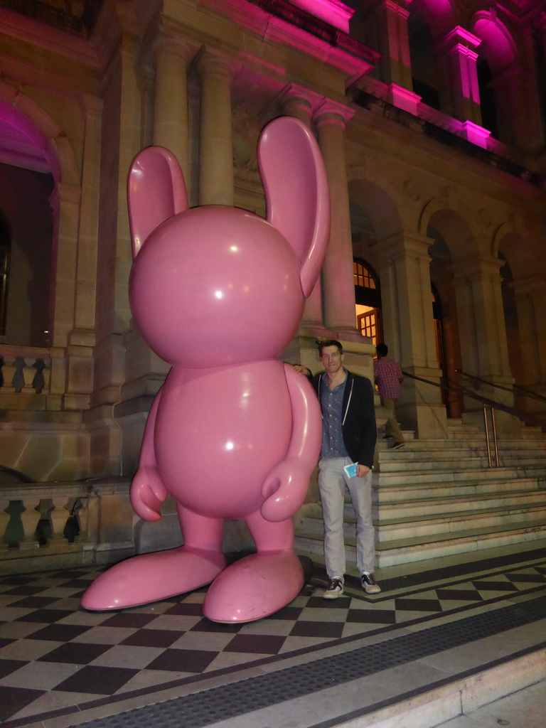 Tim with a rabbit statue in front of the Treasury Casino at Queen Street, by night