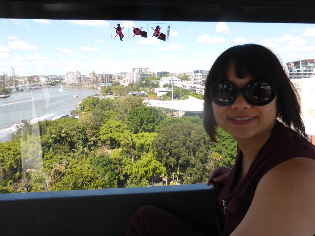 Miaomiao in the Wheel of Brisbane, with a view on the South Bank Parklands, the Goodwill Bridge and the Captain Cook Bridge over the Brisbane River and the Brisbane Cricket Ground