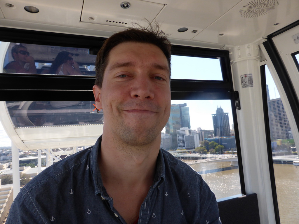 Tim in the Wheel of Brisbane, with a view on the Victoria Bridge over the Brisbane River and the skyline of Brisbane