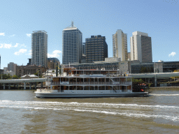 `Kookaburra Queen II` boat in the Brisbane River and skyscrapers at the city center, viewed from the ferry