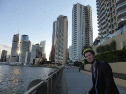 Tim on his CityCycle bicycle at the City Reach Boardwalk, with a view on the skyline of Brisbane and the Brisbane River