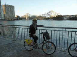 Miaomiao on her CityCycle bicycle at the City Reach Boardwalk, with a view on the Story Bridge over the Brisbane River