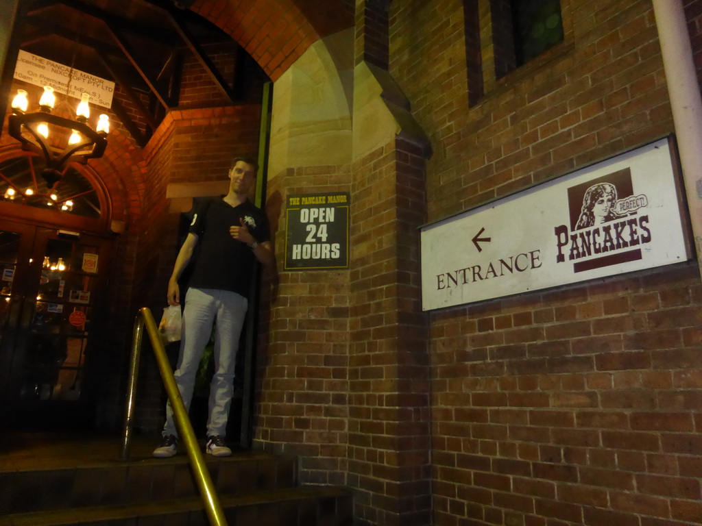 Tim at the entrance of the Pancake Manor restaurant at Charlotte Street, by night