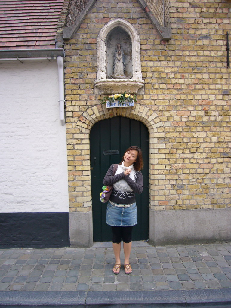 Miaomiao with a statuette of St. Mary in a small chapel at the Oostmeers street