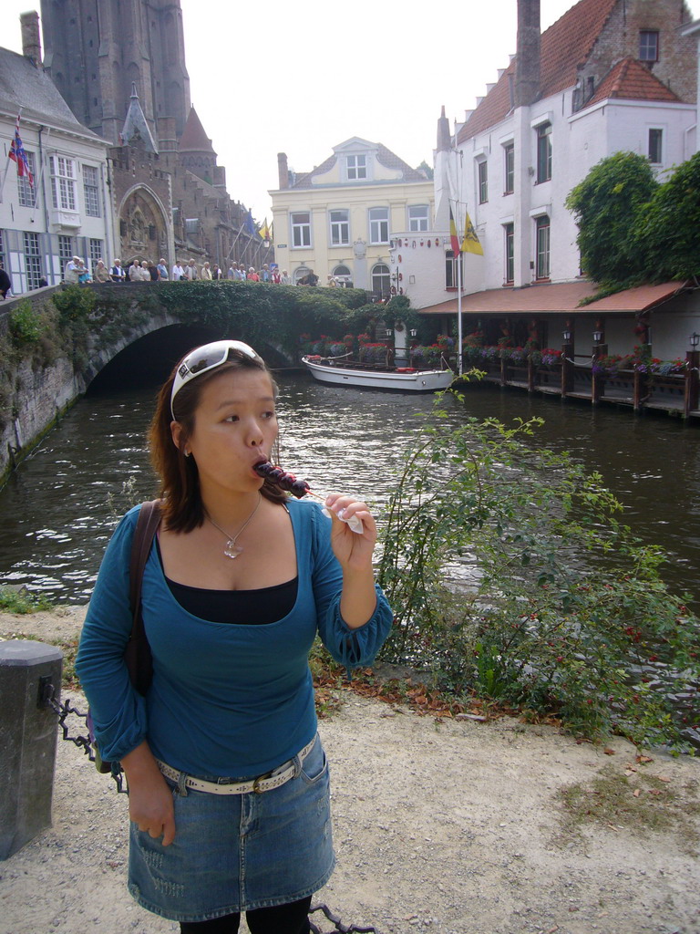 Miaomiao with a lollipop in front of the Gruuthusebrug over the Dijver canal and the Church of Our Lady