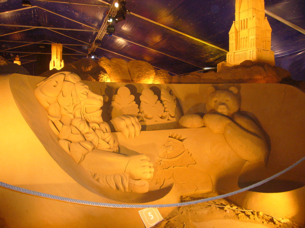 Sand sculptures of the coat of arms of Bruges, the Belfort tower and the St. Salvator`s Cathedral, at the Sand Sculpture Festival at the Stationspark