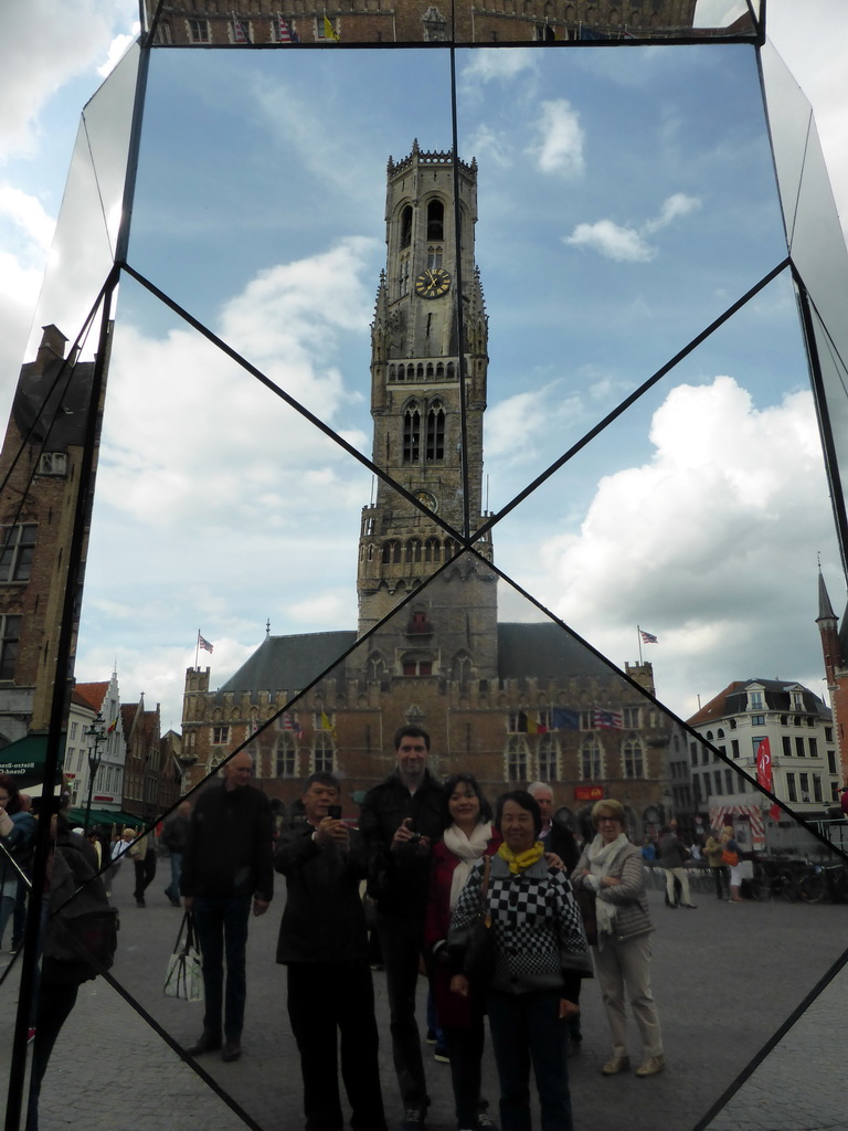 Tim, Miaomiao and Miaomiao`s parents, reflected in a mirror on the Markt square, with a view on the Belfort tower