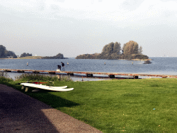 Surfboards and people catching crabs on a pier at the the back side of the Paviljoen Meerzicht restaurant