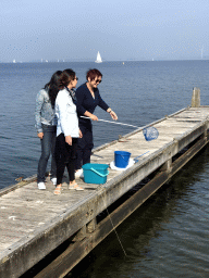 Miaomiao and other people catching crabs on a pier at the northwest side of the Grevelingendam