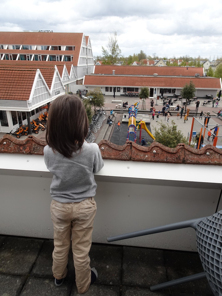 Max on the balcony of the upper floor of our apartment at Holiday Park AquaDelta, with a view on the mascot Koos Konijn at the central square
