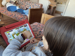 Max with a watch playing `My Singing Monsters` on the iPad in the living room at the upper floor of our apartment at Holiday Park AquaDelta