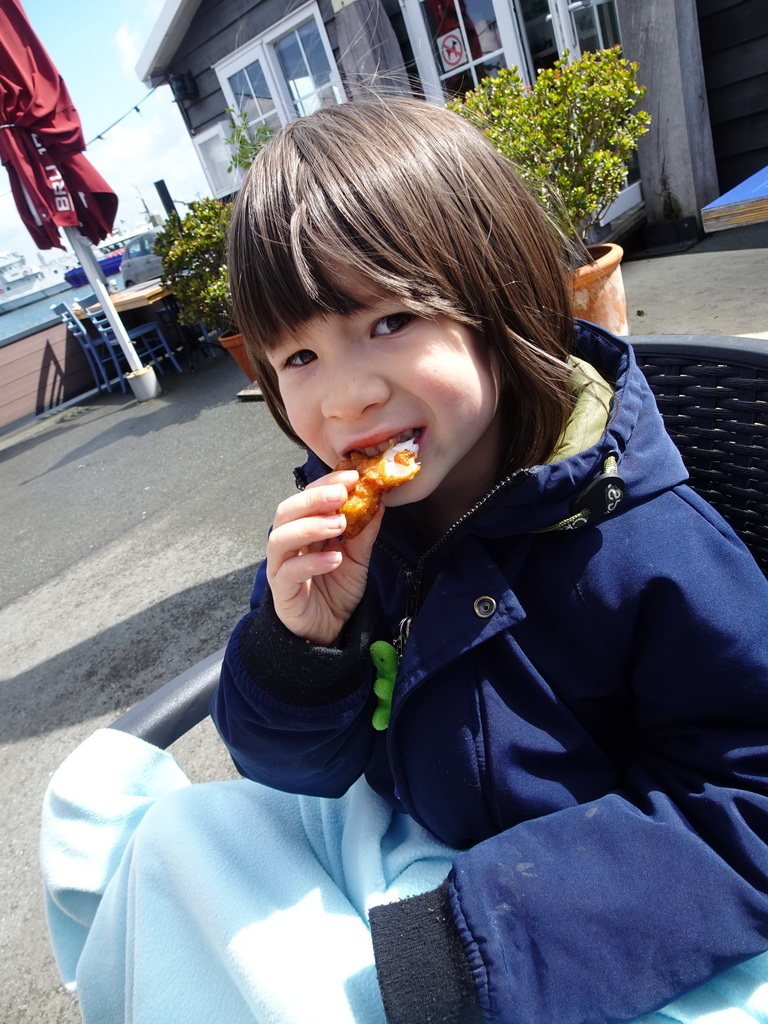 Max eating fried cod at the terrace of the Bru 17 restaurant