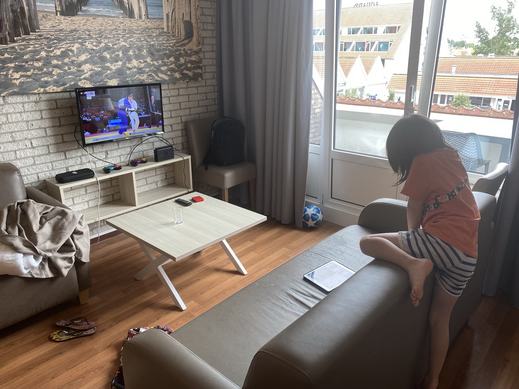 Max watching iPad in the living room at the upper floor of our apartment at Holiday Park AquaDelta, with the 2020 Olympics on television