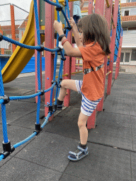 Max in a climbing net at the playground at the central square of Holiday Park AquaDelta