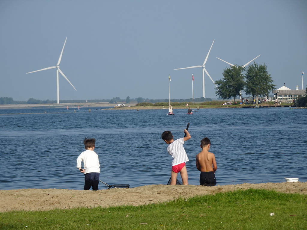 Max and his friends catching jellyfish and crabs on a beach at the north side of the Grevelingendam, with a view on the PUURR by Rich restaurant