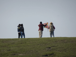 Miaomiao and our friends flying a kite on a hill at the north side of the Grevelingendam