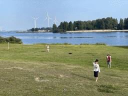 Miaomiao, Max and our friend flying kites on a beach at the north side of the Grevelingendam, with a view on the PUURR by Rich restaurant