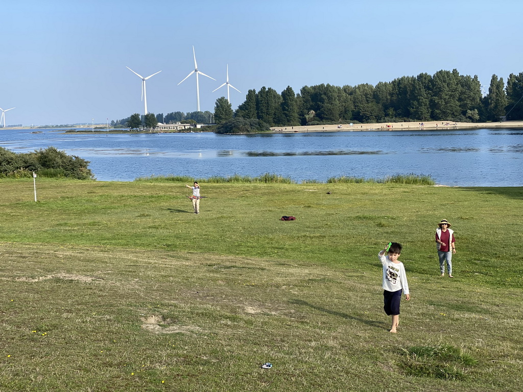 Miaomiao, Max and our friend flying kites on a beach at the north side of the Grevelingendam, with a view on the PUURR by Rich restaurant