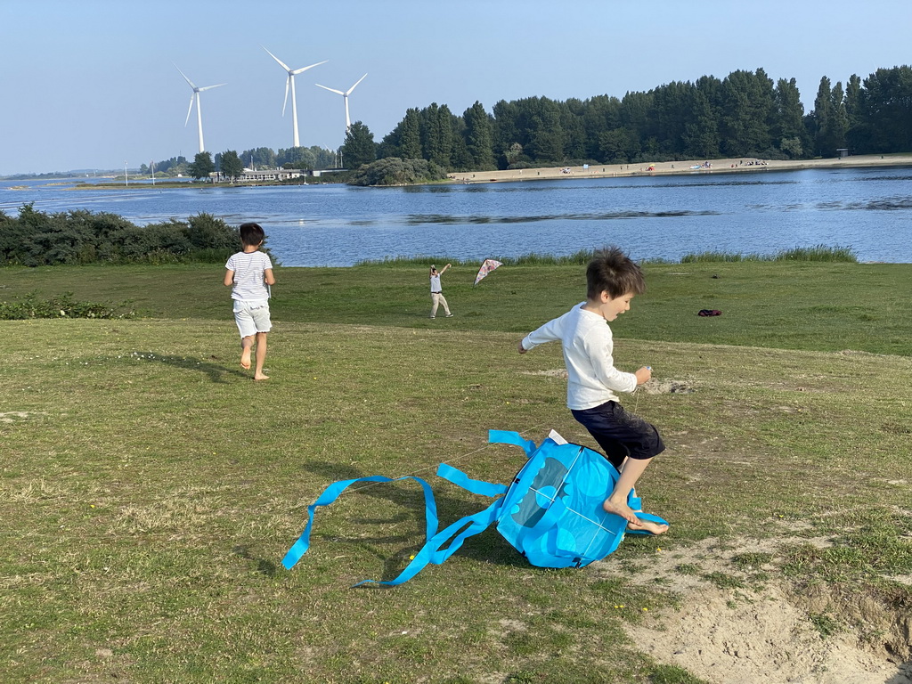 Max and our friends flying kites on a beach at the north side of the Grevelingendam, with a view on the PUURR by Rich restaurant