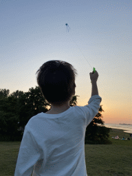 Max flying a kite on a beach at the north side of the Grevelingendam, at sunset