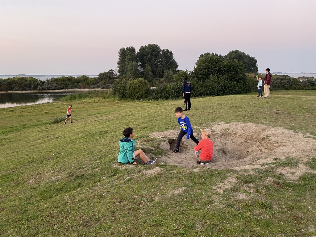 Max and our friends flying kites on a hill at the north side of the Grevelingendam, at sunset