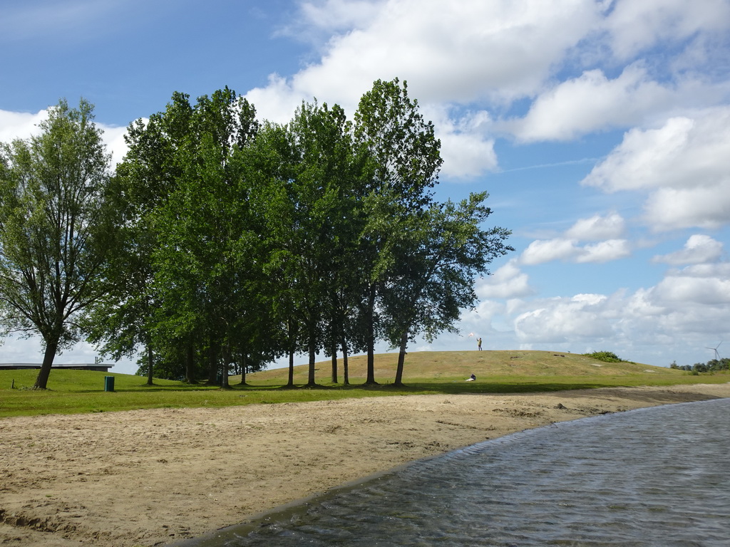 Miaomiao flying a kite on a hill at the north side of the Grevelingendam, viewed from the beach