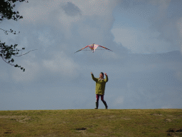 Miaomiao flying a kite on a hill at the north side of the Grevelingendam, viewed from the beach
