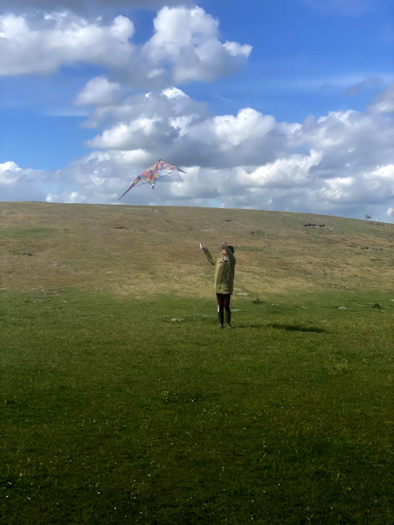 Miaomiao flying a kite on a hill at the north side of the Grevelingendam