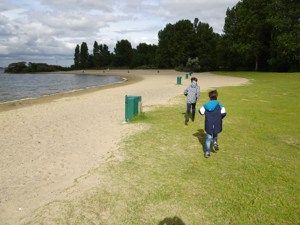 Max and our friend playing Pokémon Go on a beach at the north side of the Grevelingendam