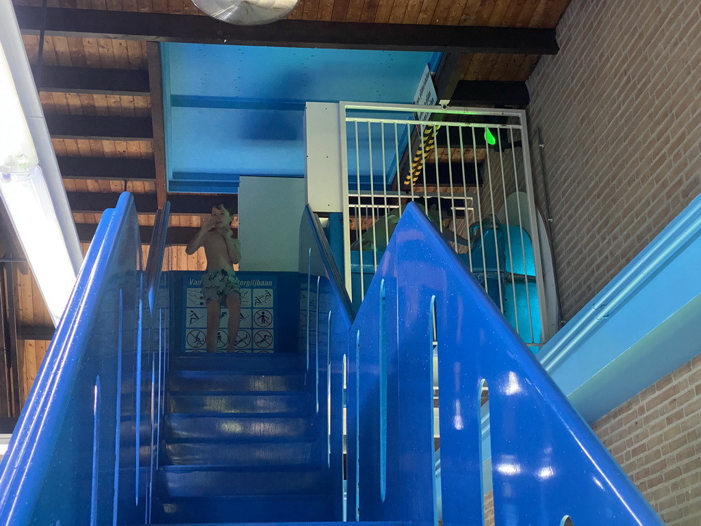 Max on the staircase to the slide at the large pool at the swimming pool at Holiday Park AquaDelta