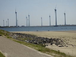 People looking for seashells at the beach at the south side of the Grevelingendam, the Krammer lake and windmills at the Krammersluizen sluices, viewed from the playground of Restaurant Grevelingen