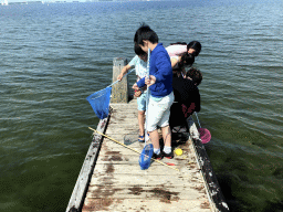 Miaomiao and other people catching crabs on a pier at the northwest side of the Grevelingendam