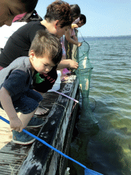 Miaomiao, Max and other people catching crabs on a pier at the northwest side of the Grevelingendam