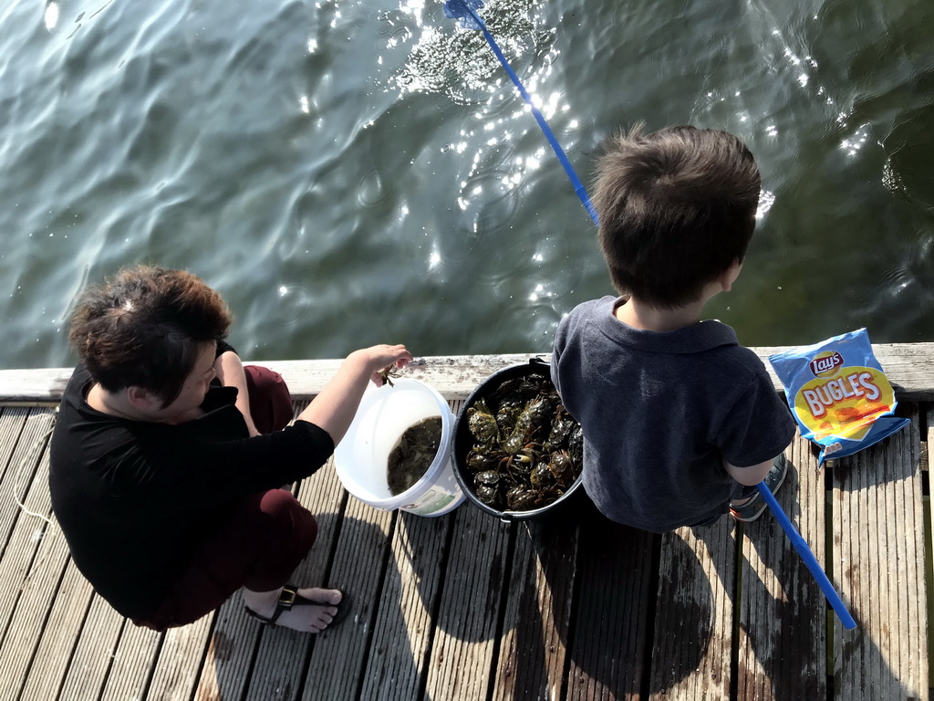 Miaomiao and Max catching crabs on a pier at the northwest side of the Grevelingendam