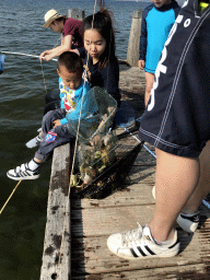 People catching crabs on a pier at the northwest side of the Grevelingendam