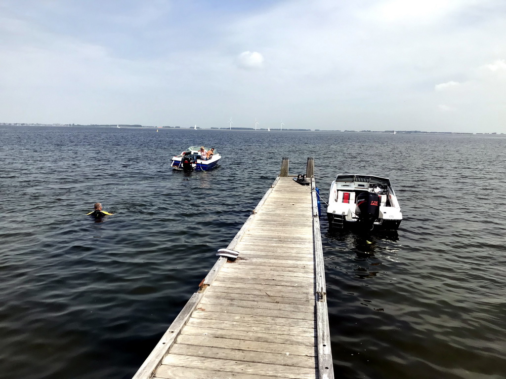 Boats and a water skier on the Grevelingenmeer lake, viewed from a pier at the northwest side of the Grevelingendam