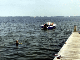 Boat and a water skier on the Grevelingenmeer lake, viewed from a pier at the northwest side of the Grevelingendam