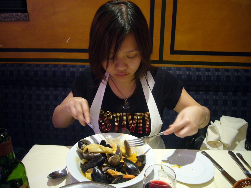 Miaomiao eating mussels in a restaurant in the Rue des Bouchers street