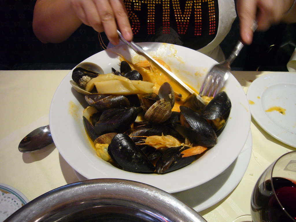 Miaomiao eating mussels in a restaurant in the Rue des Bouchers street